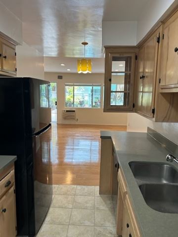 West Hollywood apartment for rent - A kitchen with wooden cabinets and a black refrigerator.