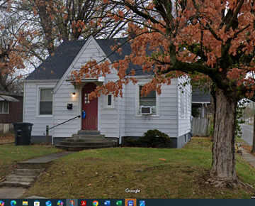 Cape Girardeau house for rent - A small white house with a red door and a tree with orange leaves in front.