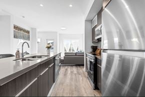 Edmonton apartment for rent - A modern kitchen with a stainless steel refrigerator and wooden flooring.