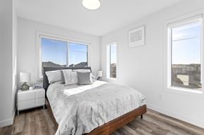 Edmonton apartment for rent - A bedroom with a large bed and a view of the mountains outside the window.