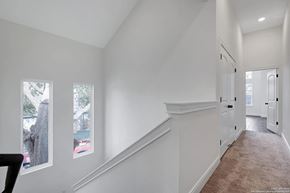 San Antonio house for rent - A long hallway with a staircase and two windows.