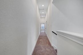 San Antonio house for rent - A long hallway with a carpeted floor and white walls.