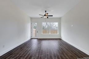 San Antonio house for rent - A room with a ceiling fan and wooden flooring.