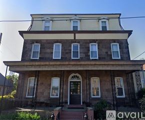 Philadelphia apartment for rent - A two-story house with a front porch and a sign that says "available".