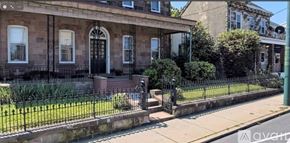 Philadelphia apartment for rent - A house with a black door and a window with bars.