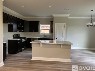 Youngsville house for rent - A kitchen with black cabinets and a beige island.
