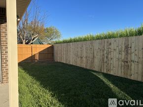 Youngsville house for rent - A backyard with a wooden fence and green grass.