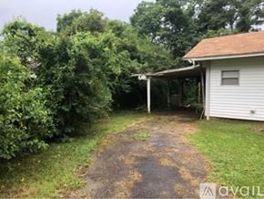 North Little Rock house for rent - A white house with a brown roof and a white garage door.