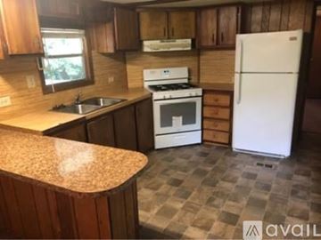 North Little Rock house for rent - A kitchen with a white fridge and a white stove top oven.