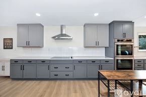 Huntsville apartment for rent - A kitchen with grey cabinets and a wooden table.