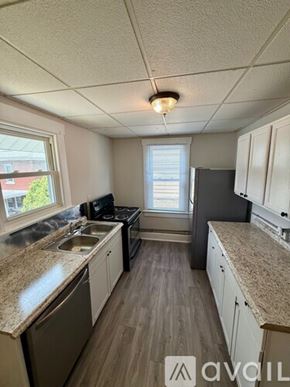 Morgantown apartment for rent - A room with a long wooden table surrounded by chairs and a bookshelf filled with books.