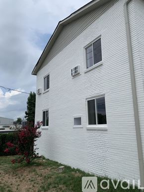 Nashville apartment for rent - A white house with a window and a bush in front.