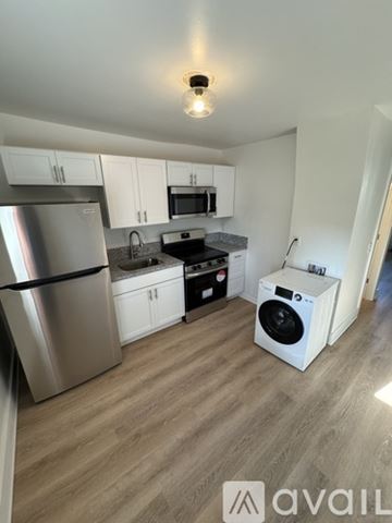 Nashville apartment for rent - A kitchen with a stainless steel refrigerator and a white washing machine.