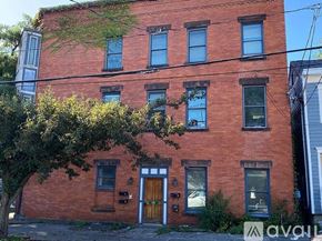 Albany apartment for rent - A red brick building with a tree in front of it.