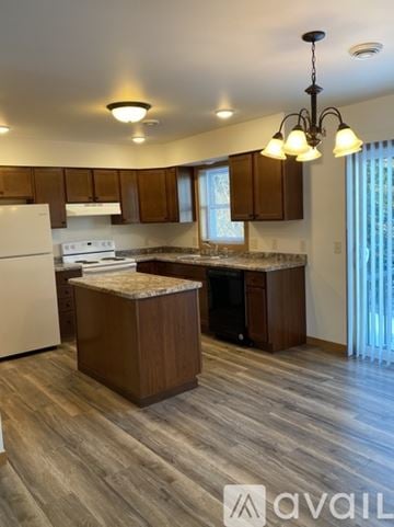 Tomah apartment for rent - A kitchen with wooden cabinets and a white fridge.