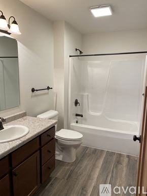 Tomah apartment for rent - A bathroom with a toilet, sink, and bathtub.