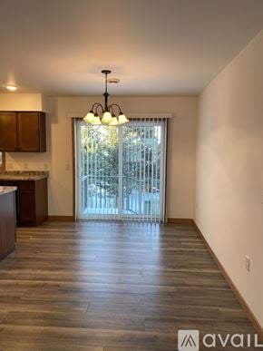 Tomah apartment for rent - A spacious room with wooden floors and a chandelier.