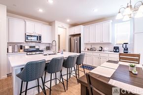 Fresno house for rent - A kitchen with white cabinets and a wooden table.