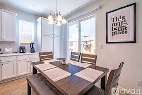 Fresno house for rent - A dining room with a wooden table and chairs, a framed picture on the wall, and a window with blinds.