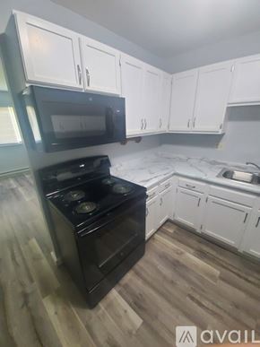 La Crosse apartment for rent - A kitchen with black appliances and white cabinets.