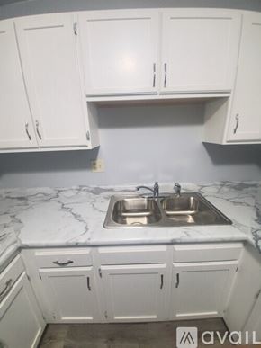 La Crosse apartment for rent - A kitchen with a marble countertop and white cabinets.