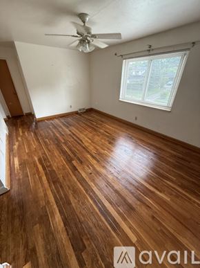 Dayton apartment for rent - A room with wooden flooring and a ceiling fan.