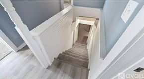 New Haven house for rent - A staircase with a beige carpeted runner and white balusters.