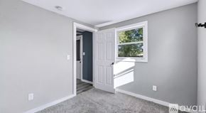 New Haven house for rent - A room with a white door and a window with a view of trees outside.