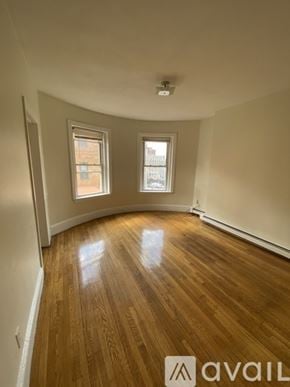 Boston apartment for rent - A room with wooden floors and two windows.