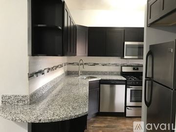Chicago apartment for rent - A kitchen with black cabinets and a granite countertop.