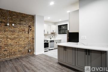 Chicago apartment for rent - A kitchen with a brick wall and wooden floors.
