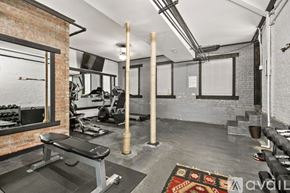 Chicago apartment for rent - A gym with a bench, weights, and a mirror.