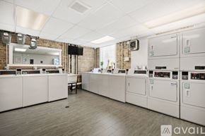 Chicago apartment for rent - A row of industrial washing machines are lined up in a room.