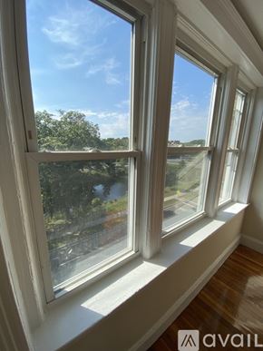 Boston apartment for rent - A window with a view of a street and trees outside.