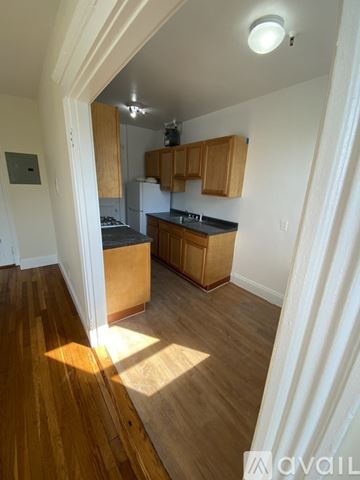 Boston apartment for rent - A kitchen with wooden cabinets and a black countertop.