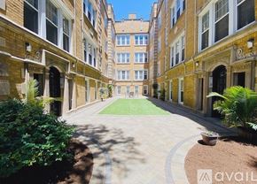 Chicago apartment for rent - A courtyard with a brick pathway and a grassy area surrounded by buildings.