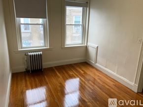Boston apartment for rent - A room with wooden floors and two windows.