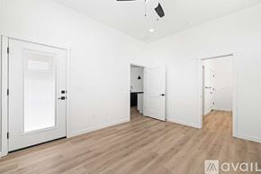 Caldwell house for rent - A room with white walls and wooden flooring, with three doors and a ceiling fan.