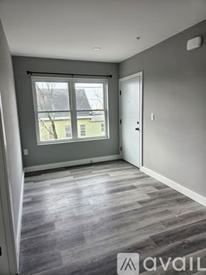 Everett apartment for rent - A room with grey flooring and a window overlooking a green building.