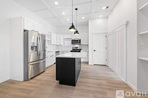 Caldwell house for rent - A modern kitchen with a black island in the middle.