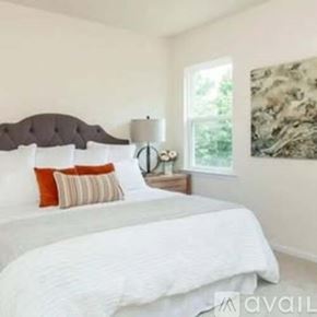 Apex apartment for rent - A bedroom with a large bed and a painting on the wall.