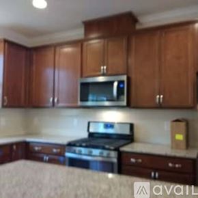 Apex apartment for rent - A kitchen with wooden cabinets and a microwave above the stove.