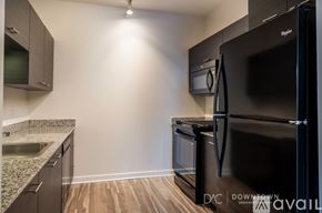 Chicago apartment for rent - A bedroom with a grey couch and a white bed.