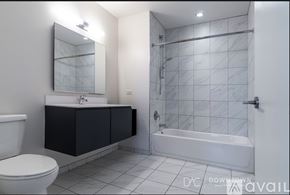 Chicago apartment for rent - A kitchen with black appliances and wooden floors.