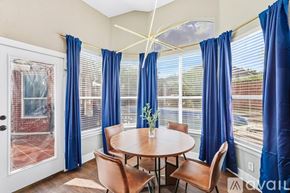 Haltom City house for rent - A dining room with a round table and blue curtains.