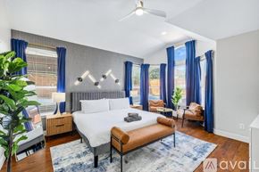 Haltom City house for rent - A well-lit bedroom with a large bed and a ceiling fan.
