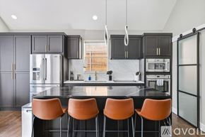 Haltom City house for rent - A kitchen with black cabinets and orange chairs.
