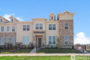 Denton townhouse for rent - A large, two-story house with a black fence in front.