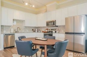 Denton townhouse for rent - A kitchen with a table and chairs in the foreground and a refrigerator in the background.