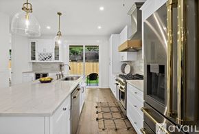 St. Augustine house for rent - A modern kitchen with white cabinets and a marble countertop.